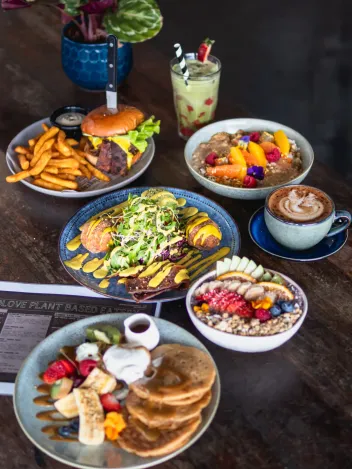 Overhead shot of vegan brunch spread featuring pancakes and coffee for Brisbane cafe social media